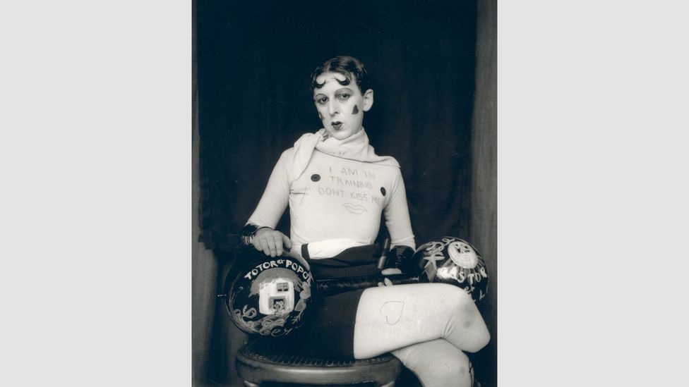 “I am in training, don’t kiss me” reads the enigmatic slogan on the artist’s jersey in this self-portrait (Credit: Jersey Heritage Collection)