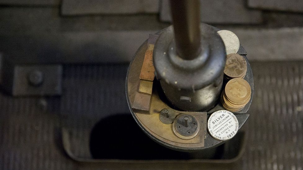 Old pennies are placed on top of the pendulum to adjust the time (Credit: UK Parliament) Old pennies are placed on top of the pendulum to adjust the time (Credit: UK Parliament)