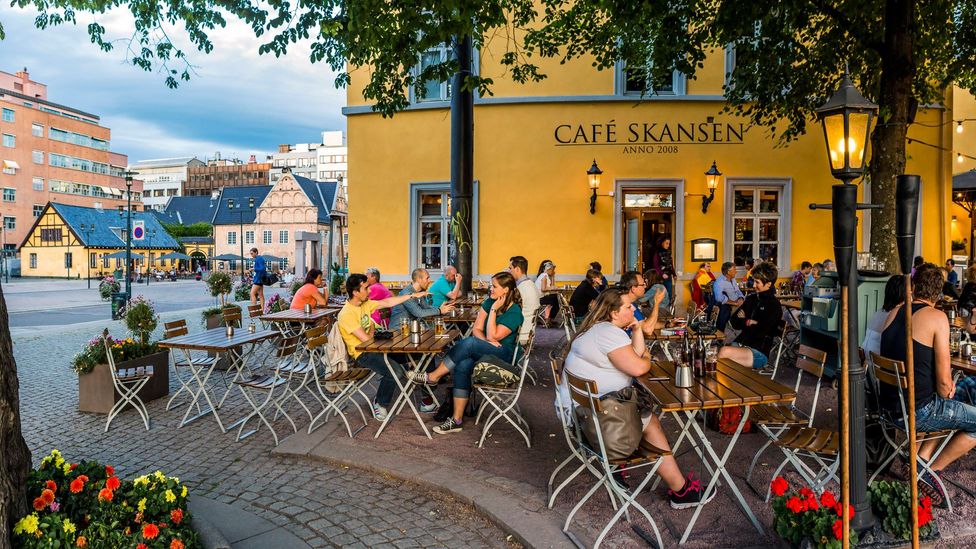 People enjoy fresh air at an outdoor cafe in Oslo (Credit: Maremagnum/Getty)