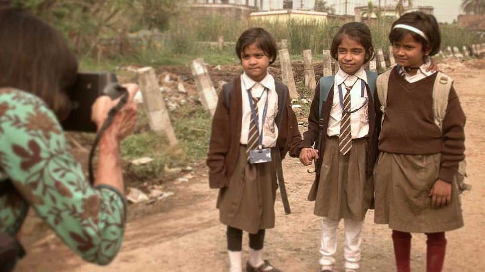 Three schoolgirls getting their photo taken (Credit: Bipasha Shom)
