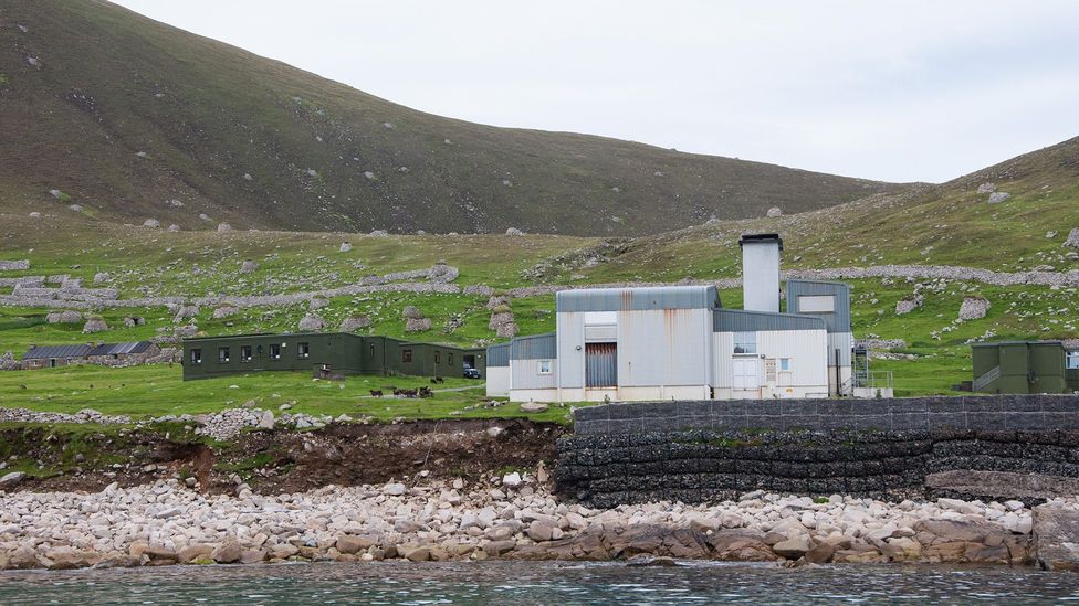 From the harbour at Hirta, the military installations run by the Ministry of Defence seem to dwarf the remnants of the abandoned village, behind (Credit: Amanda Ruggeri) From the harbour at Hirta, the military installations run by the Ministry of Defence seem to dwarf the remnants of the abandoned village, behind (Credit: Amanda Ruggeri)