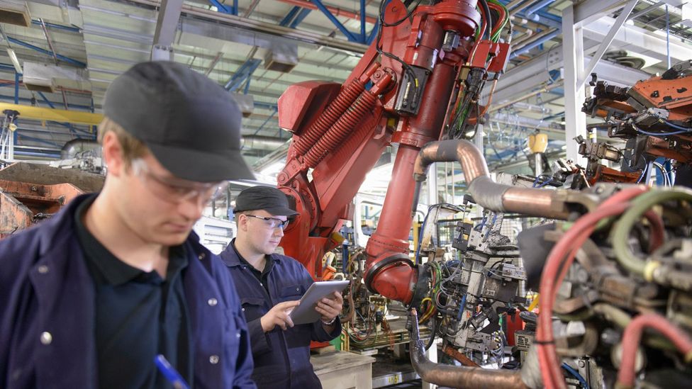 In many factories, humans already work alongside robots - some think feelings of displacement could have knock-on effects on mental health (Credit: Getty Images)