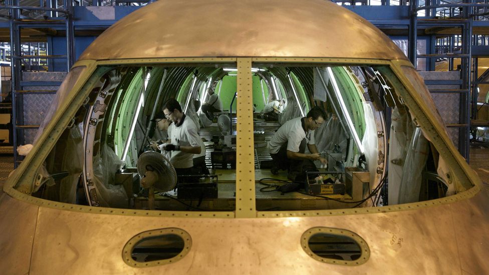 Brazilian technicians assemble an aircraft at the production line of Embraer (Credit: Getty Images)