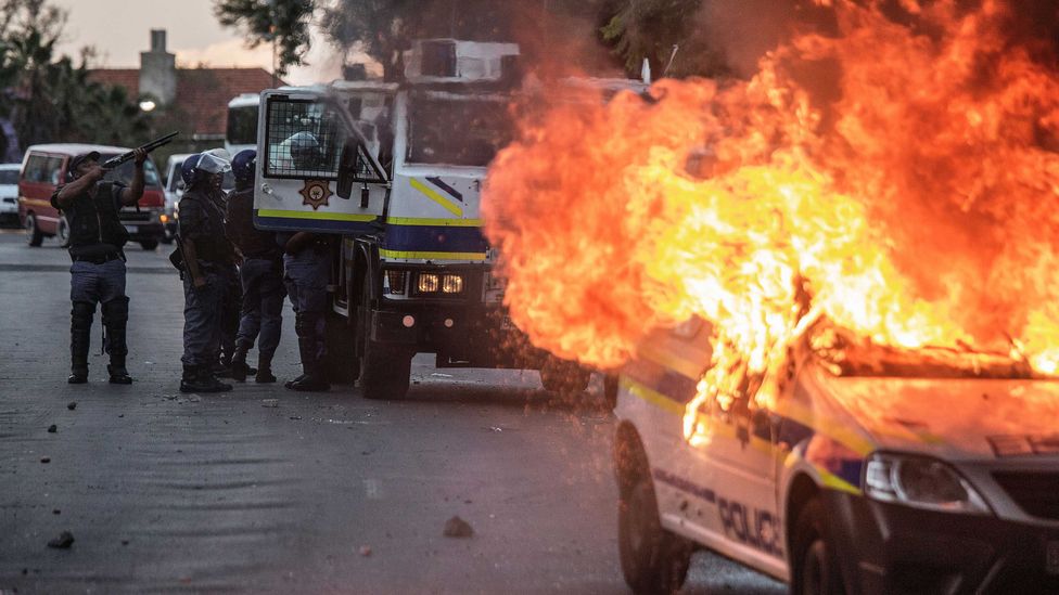 A South African police van is set on fire following protests about inequality in 2016 (Credit: Getty Images)