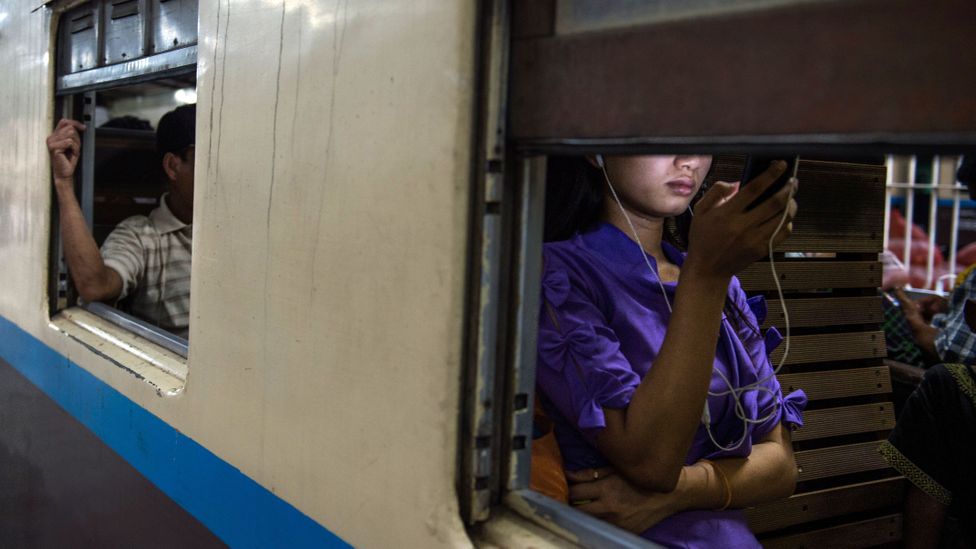 Woman using smartphone on train (Credit: Getty Images)