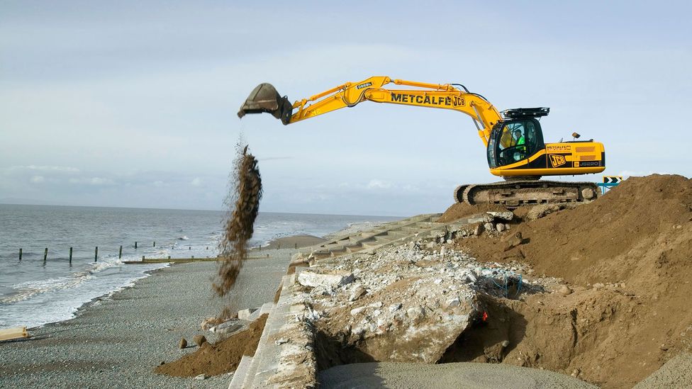 Seawalls are being built and repaired in coastal areas that face rising sea levels due to climate change - which requires able-bodied workers (Credit: Alamy Stock Photo)
