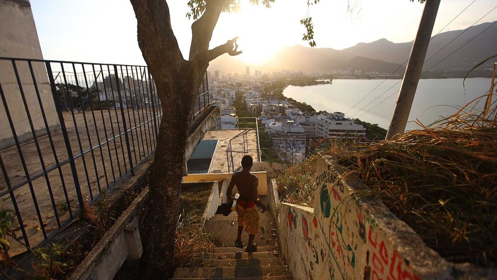 A resident walks in the Cantagalo shantytown in Rio de Janeiro, with the wealthy Ipanema seen in the distance (Credit: Getty Images)