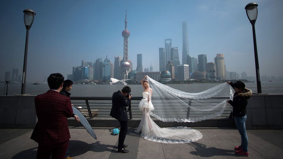 A woman poses for a wedding picture at the Bund in front of the financial district of Pudong in Shanghai (Credit: Getty Images) A woman poses for a wedding picture at the Bund in front of the financial district of Pudong in Shanghai (Credit: Getty Images)
