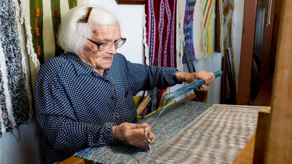 Centenarian Ionna Proiou continues to weave bags and clothes to sell in her shop (Credit: Marissa Tejada)