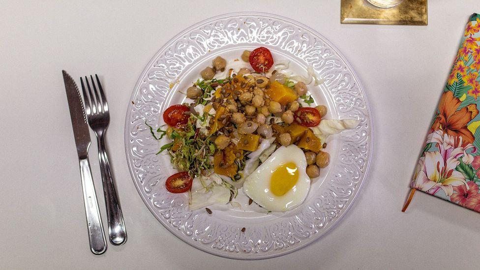 A veggie-heavy lunch: butternut squash, chickpeas, mixed salad, sunflower seeds, tomatoes and an egg cooked in the microwave
(Credit: Thiago Zanato) A veggie-heavy lunch: butternut squash, chickpeas, mixed salad, sunflower seeds, tomatoes and an egg cooked in the microwave
(Credit: Thiago Zanato)