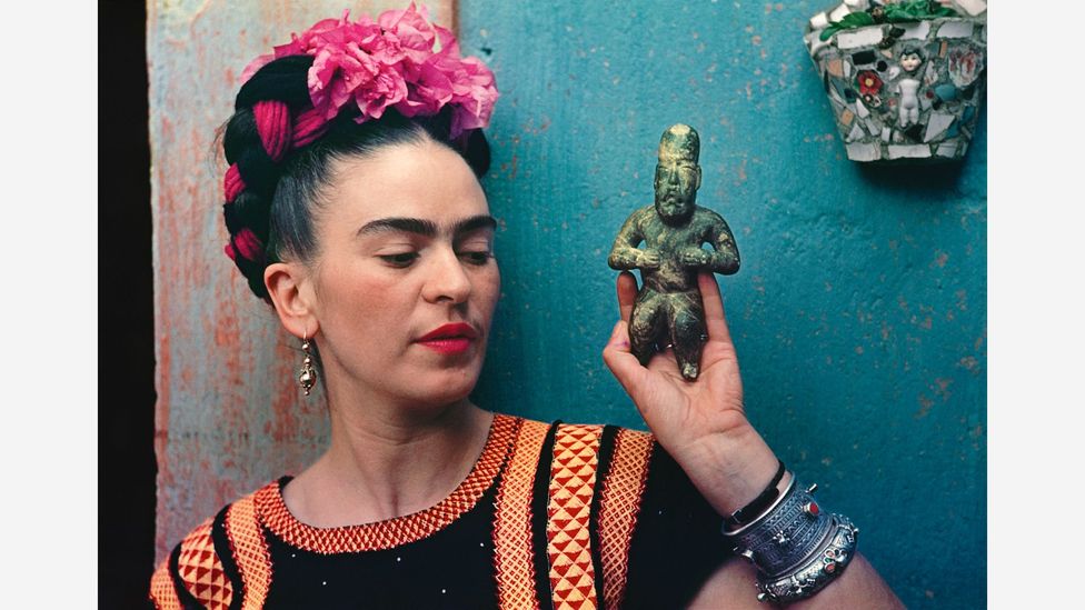 Frida Kahlo’s iconic status owes much to her striking self-portraits, like this one, with an Olmec figurine, from 1939 (Credit: Nickolas Muray/Victoria and Albert Museum)