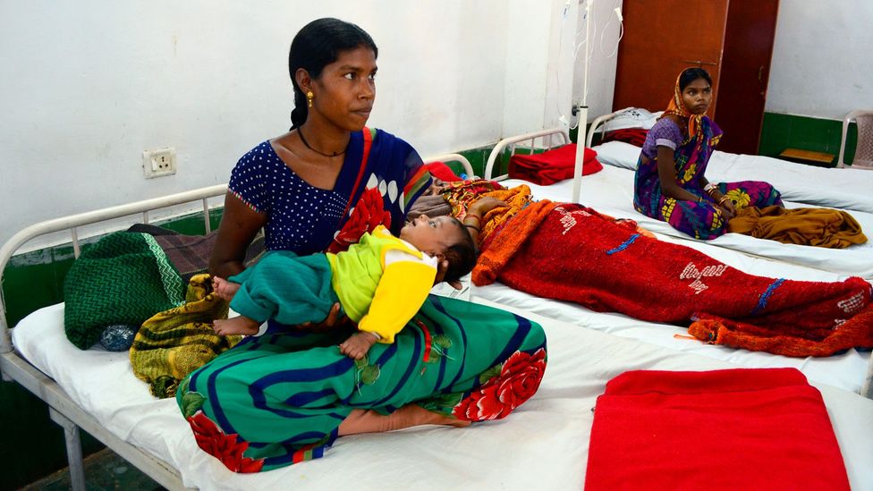 One of the women who suffered complications during the 2014 mass sterilisation that killed 13 women, Anita Bai tends to her child while under care in hospital (Credit: Getty)