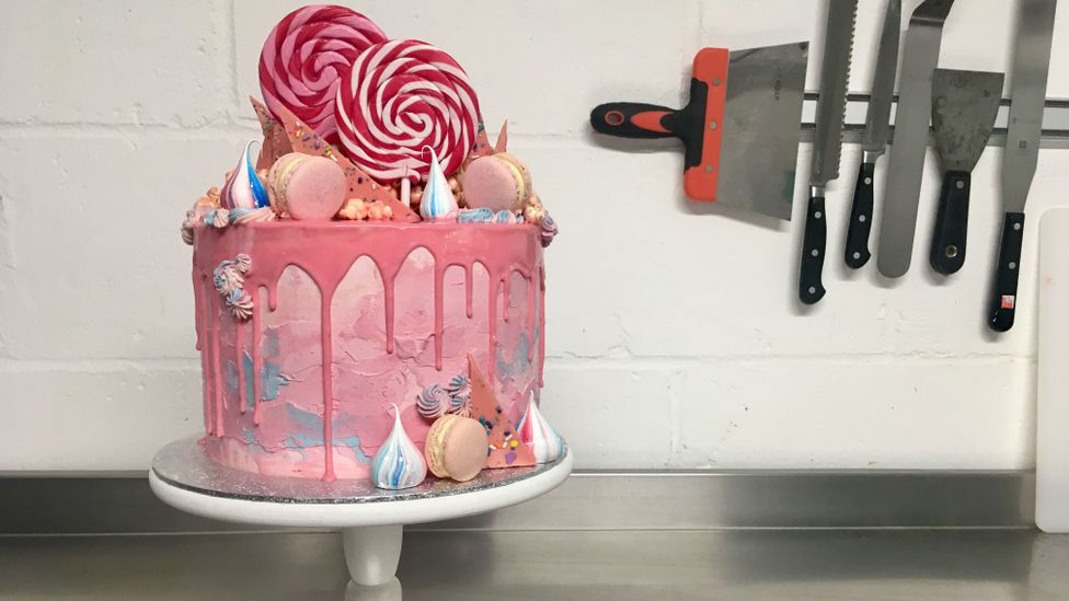 Georgia Green is a baker who designs cakes that feature pink ganache drips, macarons, meringue kisses, white chocolate popcorn and swirly lollipops (Credit: Elizabeth Hotson)