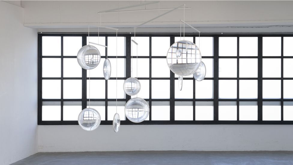 The kinetic piece, Focus, by architect Yuji Okitsu comprises clear glass lenses suspended in front of a window that refract light around the room