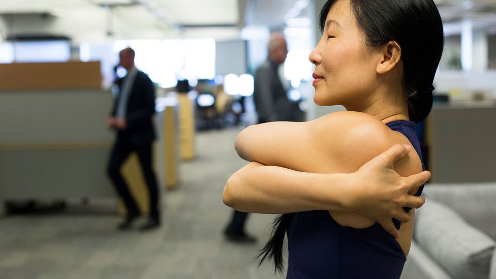 A fitness instructor teaches offices workers yoga techniques in Toronto (Credit: Getty Images) A fitness instructor teaches offices workers yoga techniques in Toronto (Credit: Getty Images)