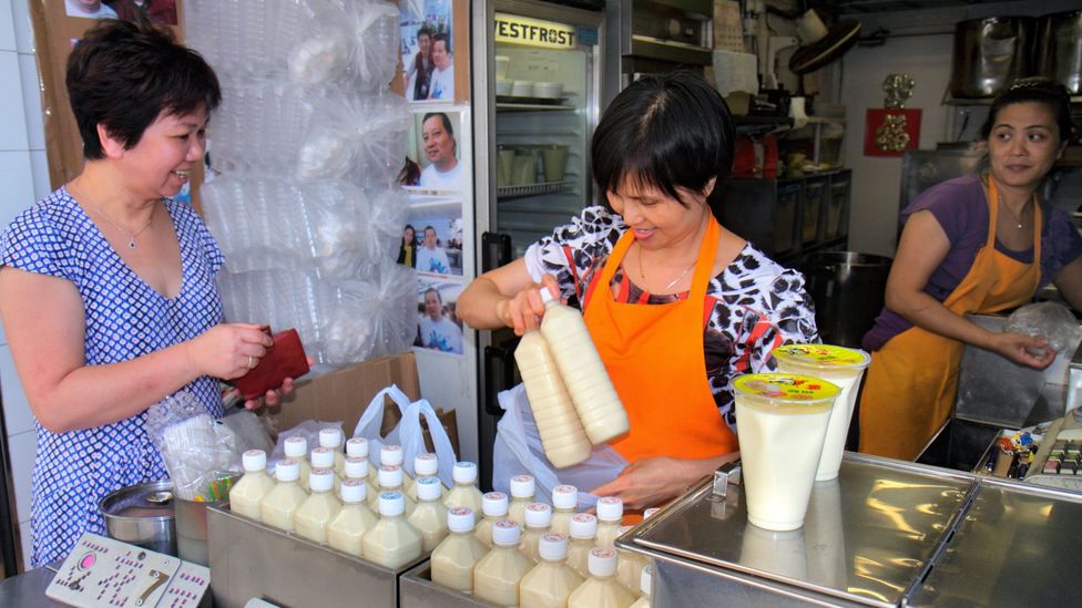 A woman purchases soy milk in Hong Kong. Dairy can make many people feel sick in Asia, where the lactase persistence trait is uncommon (Credit: Getty)