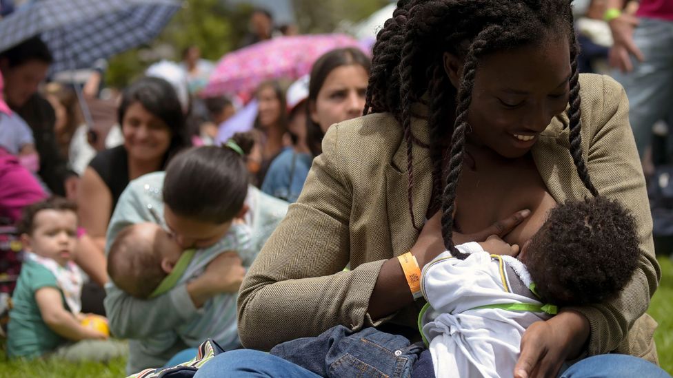Women nurse their children in Bogota, Colombia for a World Breastfeeding Week event. Milk’s protective effect is thought to be a benefit of breastfeeding (Credit: Getty)
