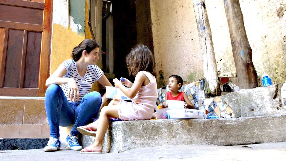Elisa Mansur sits with children
