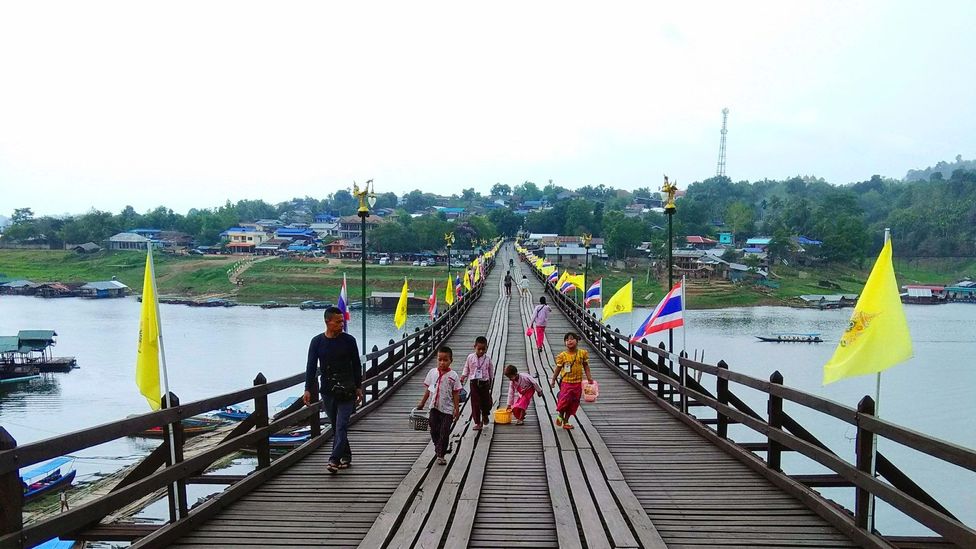 People walk across the Mon Bridge in Sangkhlaburi, Thailand People walk across the Mon Bridge in Sangkhlaburi, Thailand