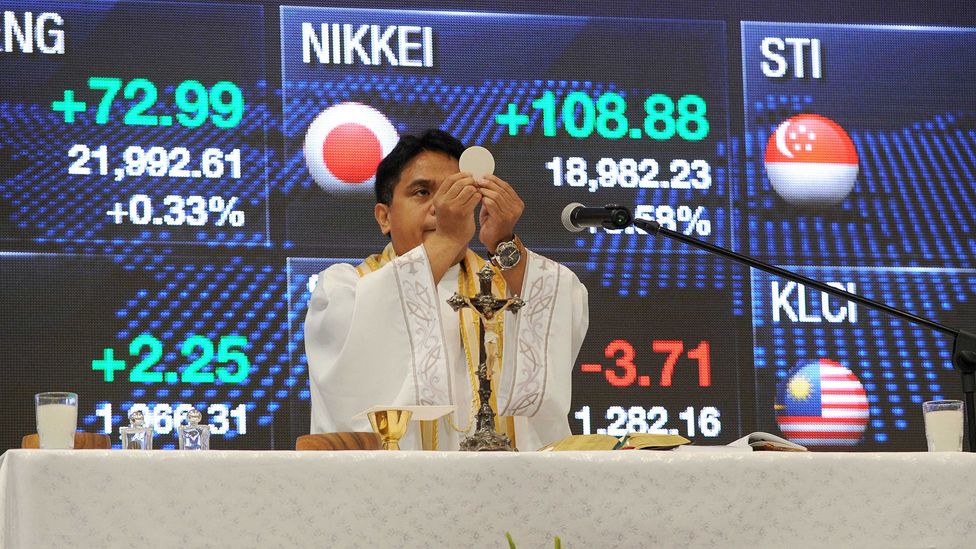 A Roman Catholic priest officiates mass on the first day of trading at the Philippine Stock Exchange in Manila (Credit: Getty Images)