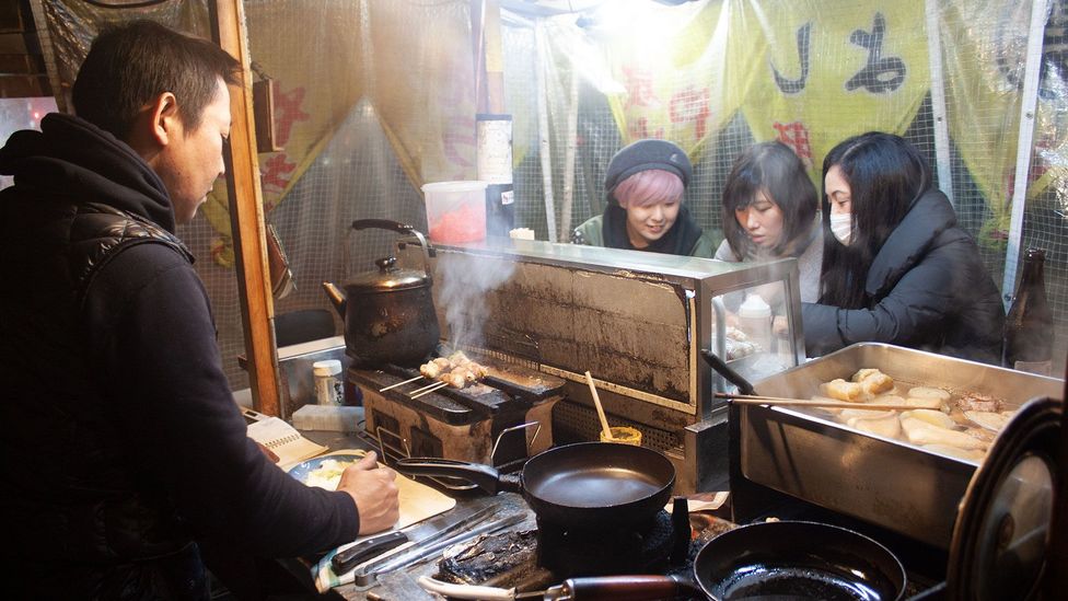 Eiji Abe prepares food at his yatai Maruyoshi. He argues that yatai are informal spaces that allow people to let down their guard with strangers (Credit: Edd Gent)