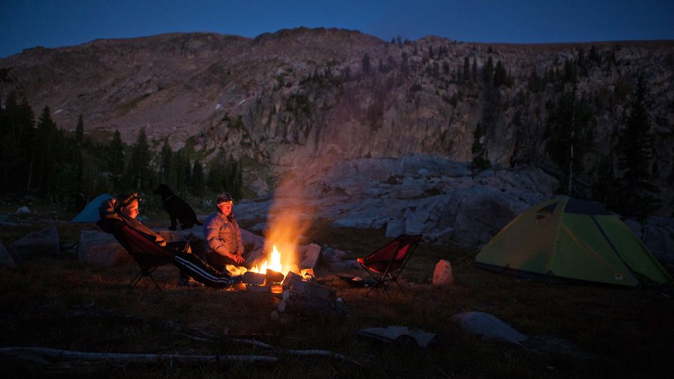 After a long day in the mountains, two researchers relax next to a campfire (Credit: Matt Stirn)