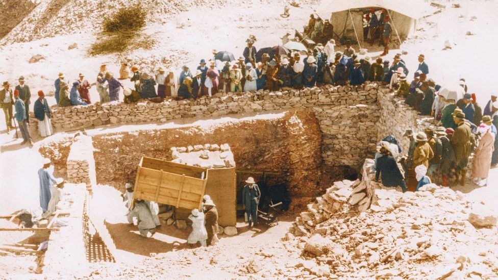 1923, Thebes: tourists crowd around the entrance to the tomb to watch a large object being removed from Tutankhamun's tomb, on its way to the workroom