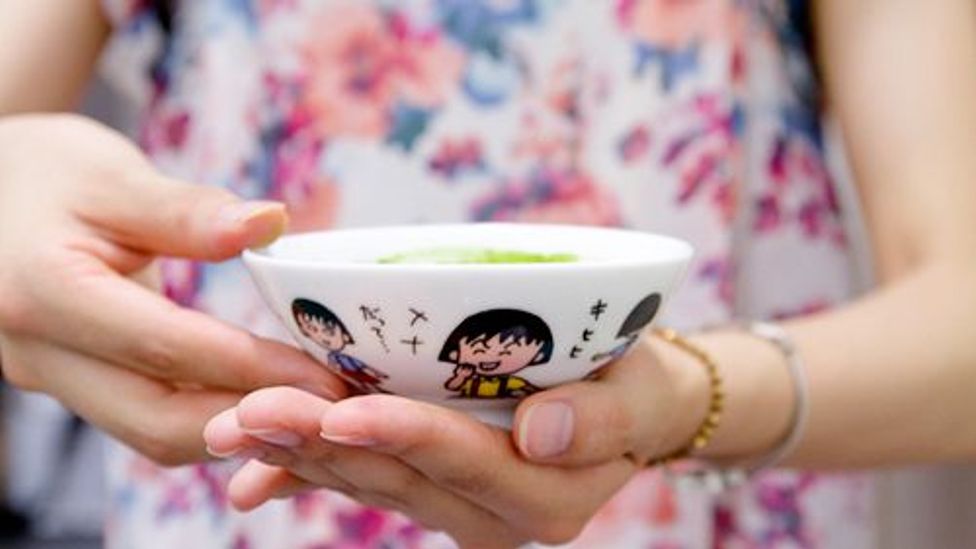 A participant holds a cup she has used since childhood. The retro anime on it gives a feeling of nostalgia (credit: Sakiko Kishimoto)
