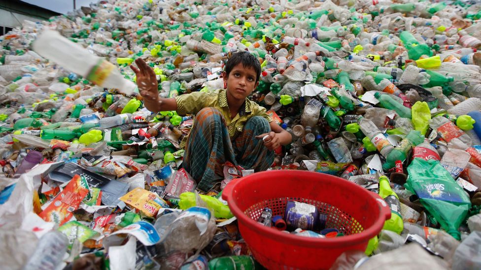 A Bangladeshi child sifts through waste (Credit: Getty Images)