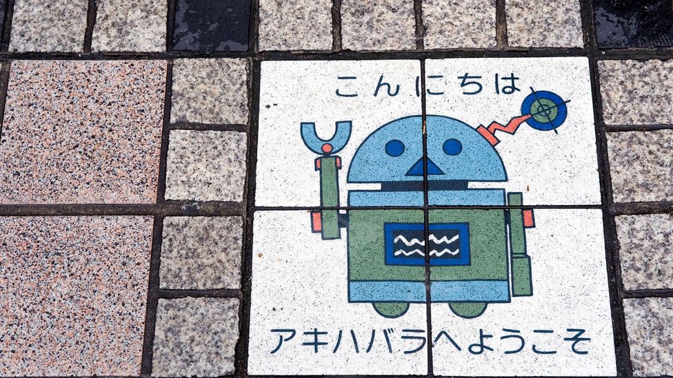 Robot artwork on the sidewalk says, "Konnichiwa" (Hello)