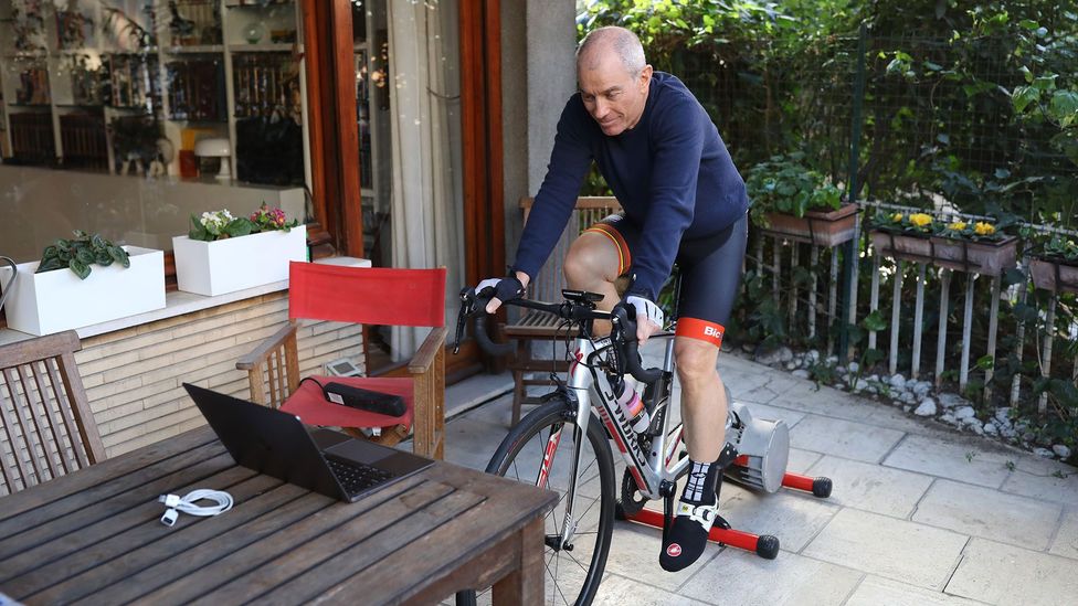 A cyclist in Italy trains at home on a stationary bike to avoid leaving his home as the country continues a nation-wide lockdown amid the Covid-19 pandemic (Credit: Getty Images)