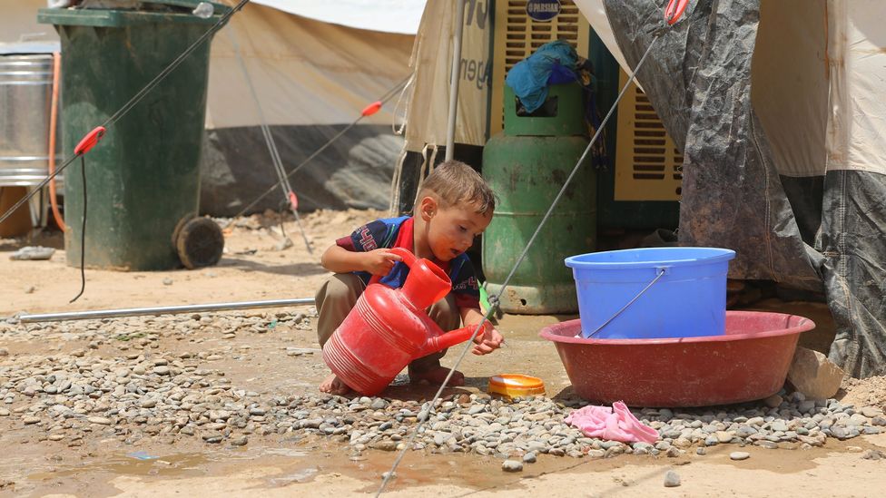 A boy washes at the Dibege Refugee Camp in Iraq; ensuring that there are handwashing stands and soap is key to fighting Covid-19's spread in refugee camps (Credit: Getty Images)