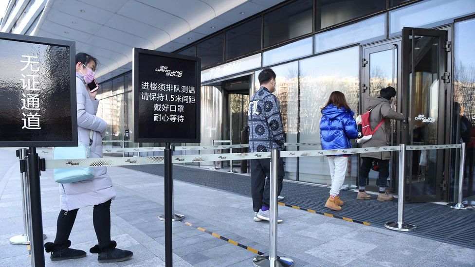 People wait in a queue to have their temperature and identity information checked at an entrance to office in Beijing, China (Getty Images) People wait in a queue to have their temperature and identity information checked at an entrance to office in Beijing, China (Getty Images)