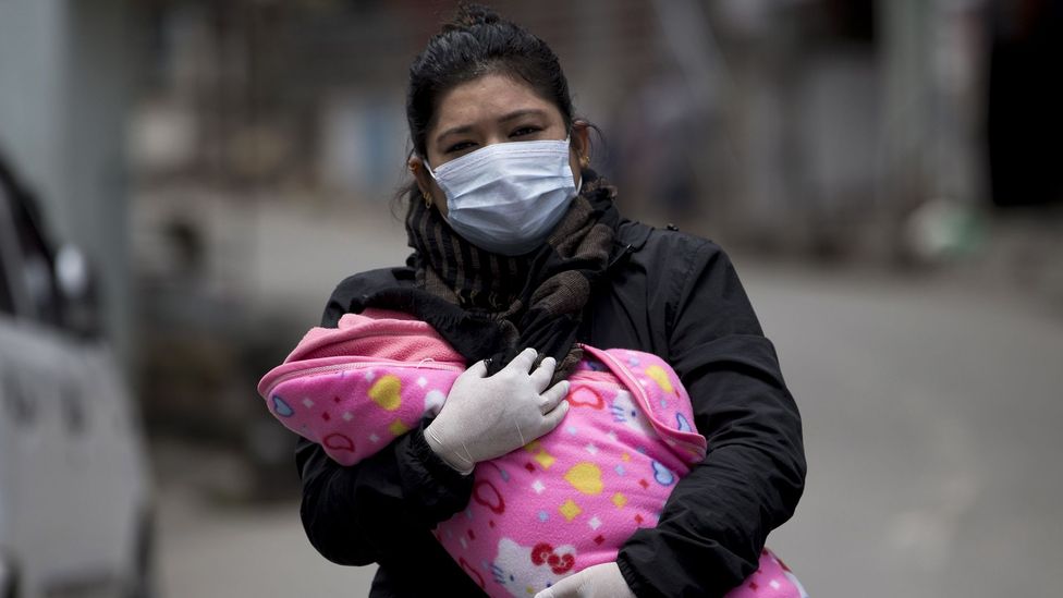 A woman carrying her child to be vaccinated (Credit: EPA)