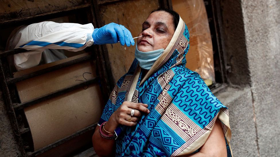 A medical worker collects a sample to test for Covid-19 in New Delhi; many people who have the virus are never tested (Credit: Reuters)