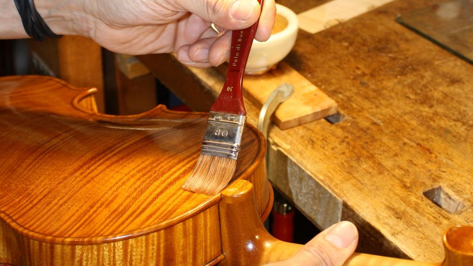 Here seen varnishing a violin, Argentinian-born craftsman Pablo Farias is among more than 160 luthiers who currently live and work in Cremona (Credit: Michela Vado)