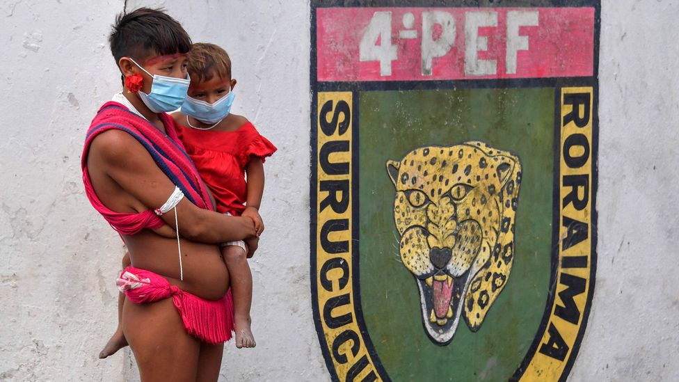 A woman and baby from the Amazon’s Yanomami tribe wear face masks at a Covid-19 testing centre (Credit: Getty Images)