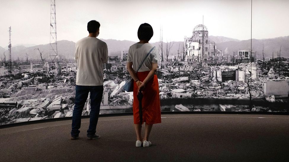Two museum visitors look at image of destruction, Hiroshima (Credit: Getty Images)