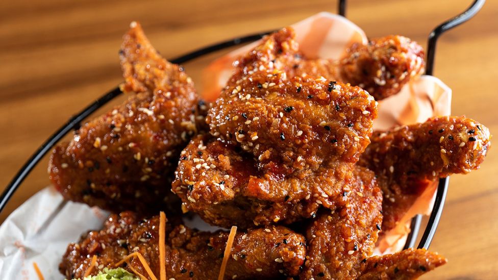 Dakgangjeong Korean fried chicken is coated with a sweetened chilli paste (Credit: Justin Ong/Getty Images)
