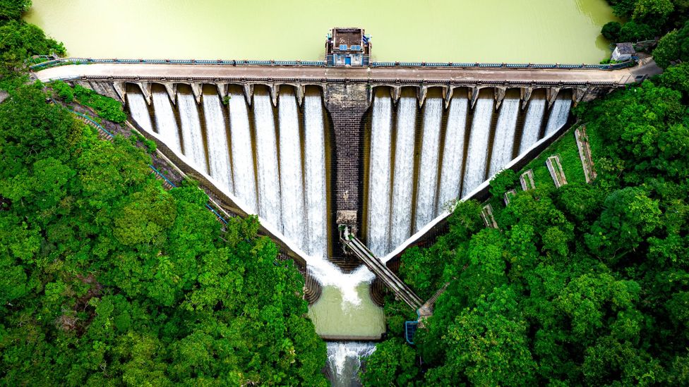 A century-old triangular-shaped dam holds back the Kowloon reservoir in Hong Kong… (Credit: Chunyip Wong/Getty Images)
