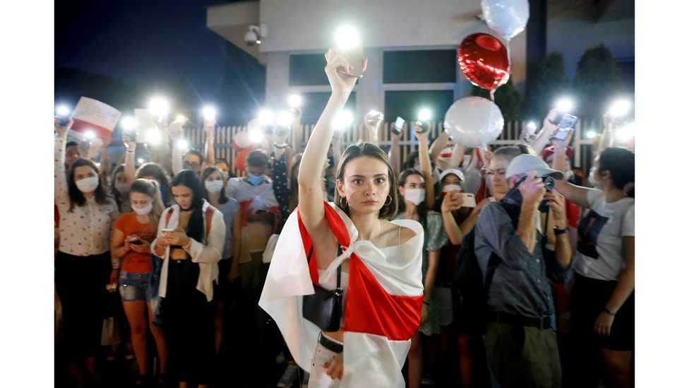 A demonstrator holds up her phone during a march after the disputed presidential election in Belarus, August 2020 (Credit: Kacper Pempel/Reuters)