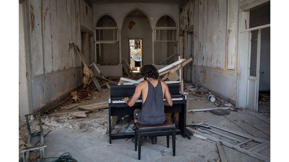 Raymond Essayan plays a piano in a destroyed building on 14 August, 2020 after the port explosion in Beirut, Lebanon (Credit: Chris McGrath/Getty Images)