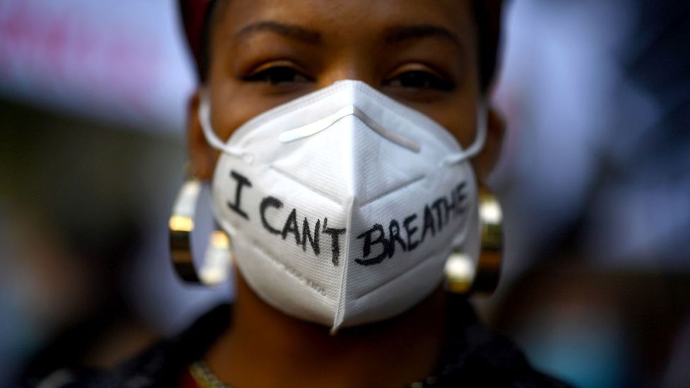 A woman wears a mask reading 