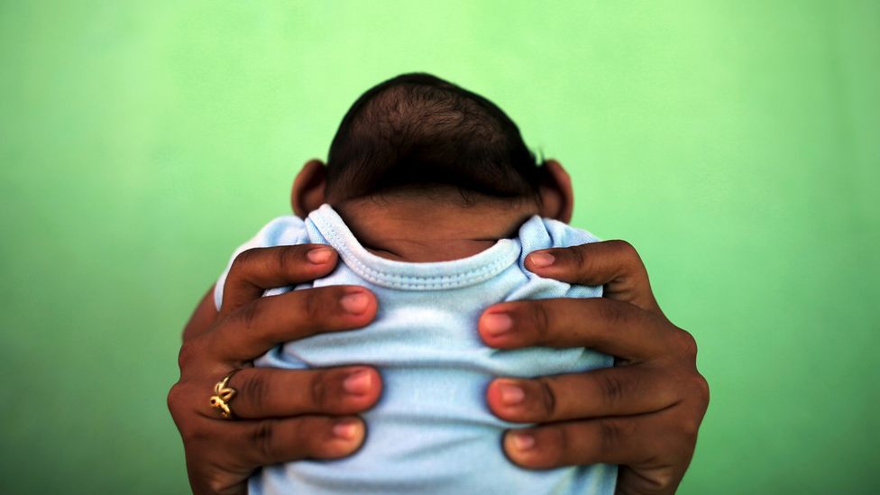 Jackeline holds her four-month-old son, who was born with microcephaly, in Brazil during the 2016 Zika outbreak (Credit: Nacho Doce/Reuters)