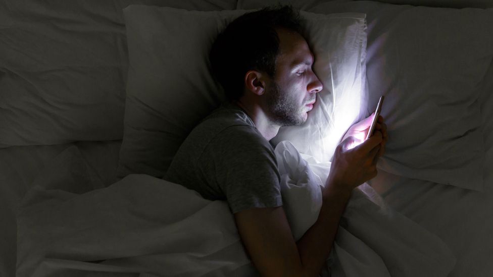 You may have a compulsion to consume news before bed, but experts say to put down the phone if you want to sleep better (Credit: Alamy)