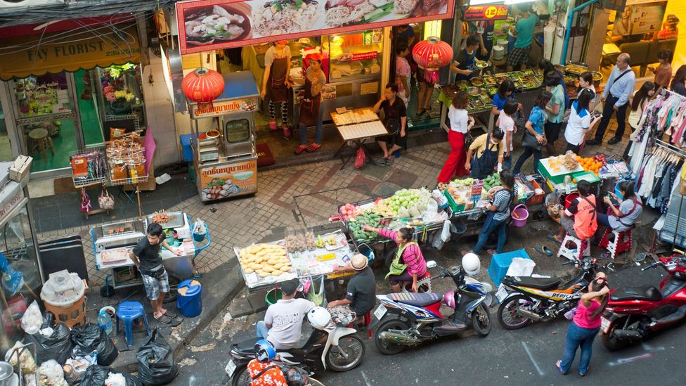 Bangkok's busy commercial areas, with local stores and street food vendors, help facilitate shared streets (Credit: Alamy)