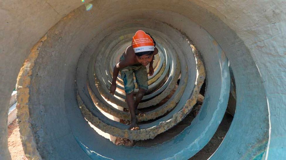 A child walks inside sewage concrete rings at Jamtola refugee camp in Ukhia, Bangladesh (Credit: Munir Uz Zaman/Getty Images)