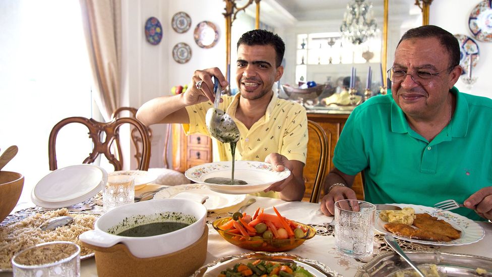 Tarek Helmy (here, with a friend) eats molokhia twice a week with rice