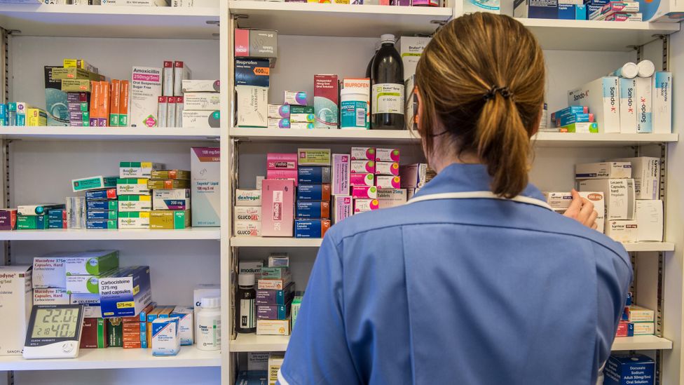 A pharmacist collecting medication from a shelf (Credit: Alamy/ Paul Slater)