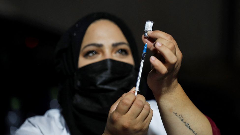 An Israeli health worker preparing to administer a booster shot (Credit: Getty Images)